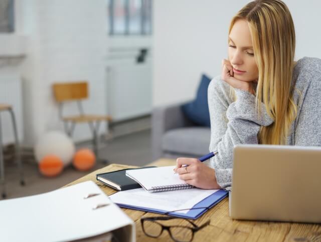 Kommunikation Fernstudium Infos junge Frau macht Notizen