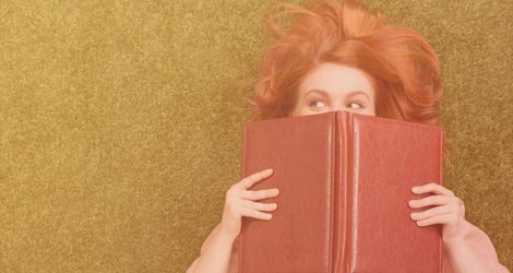 Frau mit Buch vor dem Gesicht