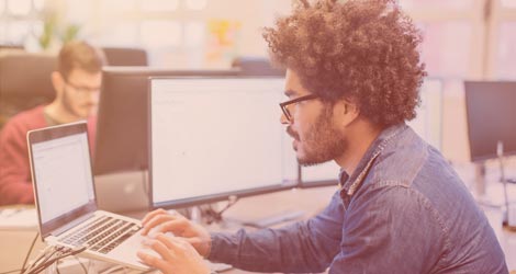 Mann arbeitet am PC im Büro