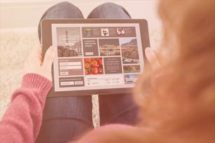 Digitale Medien Teaser Studentin hat Tablet auf dem Schoß und betrachtet etwas darauf